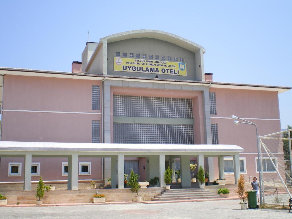 un gran edificio rosa con un cartel en él en Selcuk Uygulama Oteli̇, en Selçuk