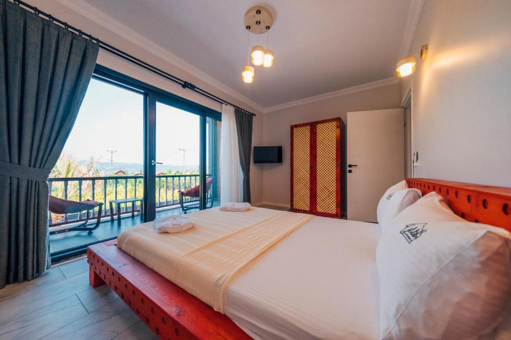a bedroom with a large bed and a balcony at Sapanca Göldibi Suit Bungalov in Sakarya