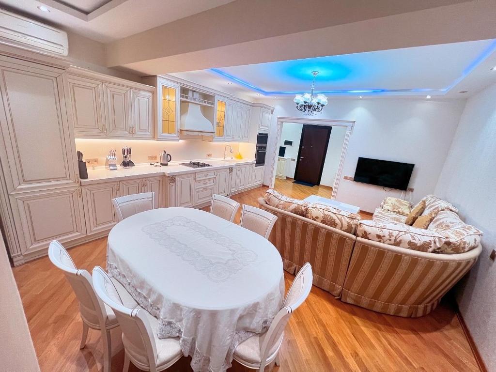 a kitchen and living room with a table and a couch at Park Azure 0313 in Baku