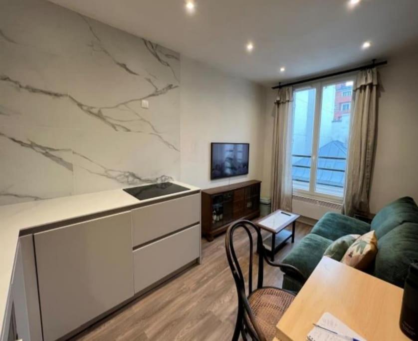 un salon avec un canapé et une télévision dans l'établissement Deux pièces au cœur de Vincennes, à Vincennes