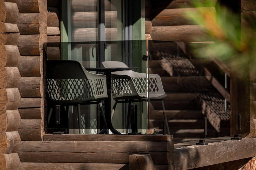 two chairs and a table on a balcony at Bukovel Hotel in Bukovel