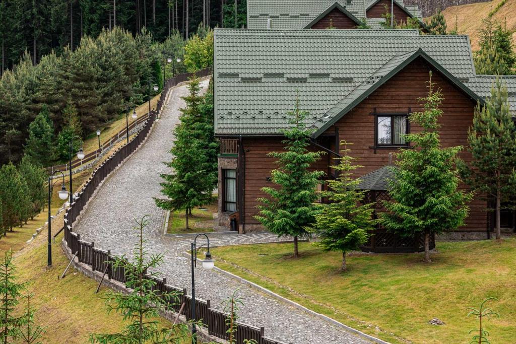 a small wooden house with a path leading to it at Bukovel Hotel in Bukovel