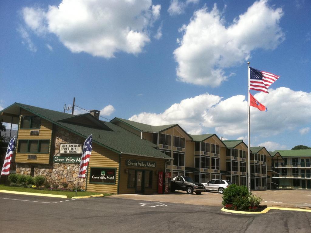 dos banderas americanas volando frente a un hotel en Green Valley Motel, en Pigeon Forge