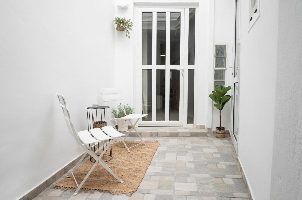 a porch with two chairs and a door at EliAna home at Venetian walls by 8essentially in Bendevís