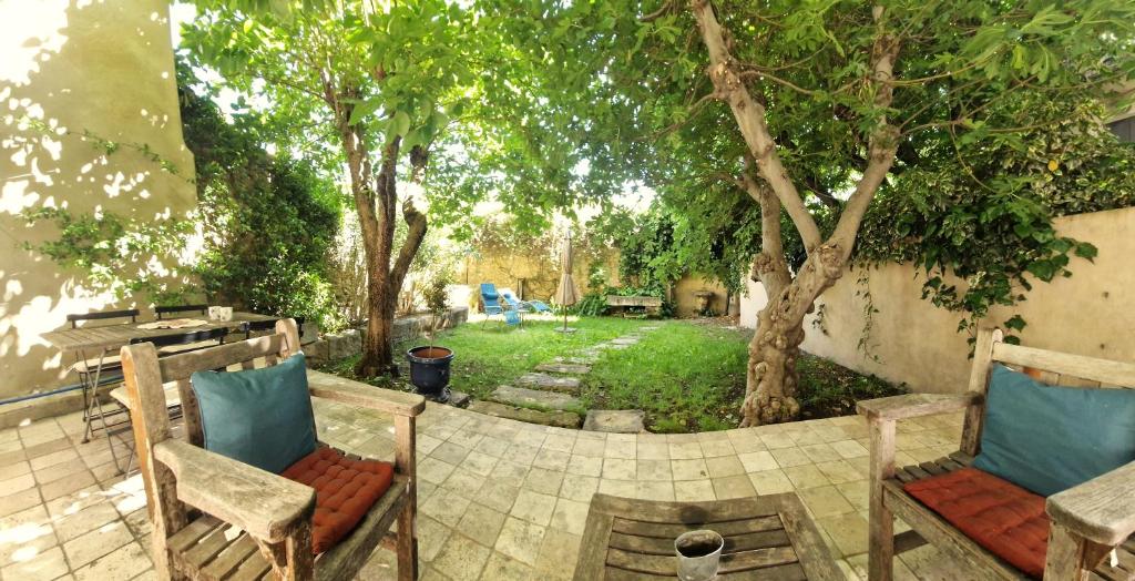 une cour avec deux chaises et un arbre dans l'établissement Le Jardin secret 100m Mairie, à Aix-en-Provence