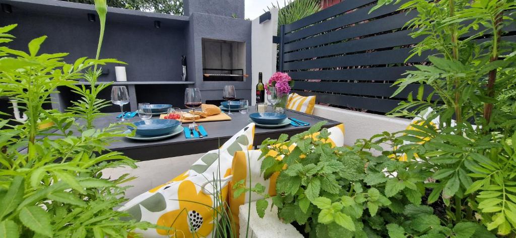 a patio with a table and some plants at Private fenced garden with BBQ area minutes from the beach - Urban Secret Kantrida in Rijeka