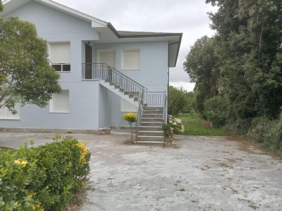 una casa blanca con una escalera al frente en Apartamento-Casa Los Cuadrillos, en Noja