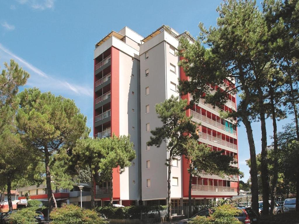 リニャーノ・サッビアドーロにあるAppartamenti Alidecoの白い高い建物の前に木々