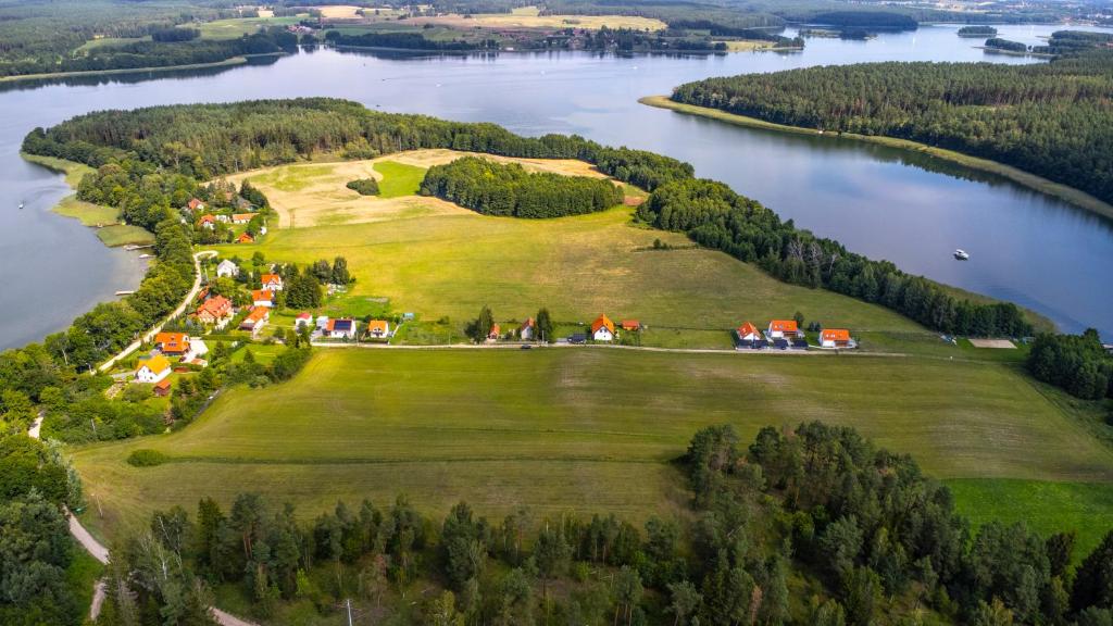an island in the middle of a lake with houses at Ant House Complex - Luksusowe domy SPA in Ryn
