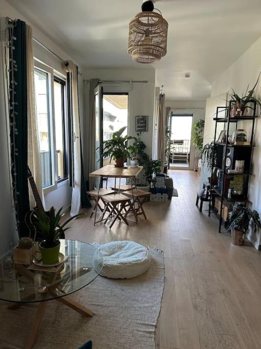 un salon avec une table en verre et des chaises dans l'établissement Appartement confortable et parking, à Asnières-sur-Seine