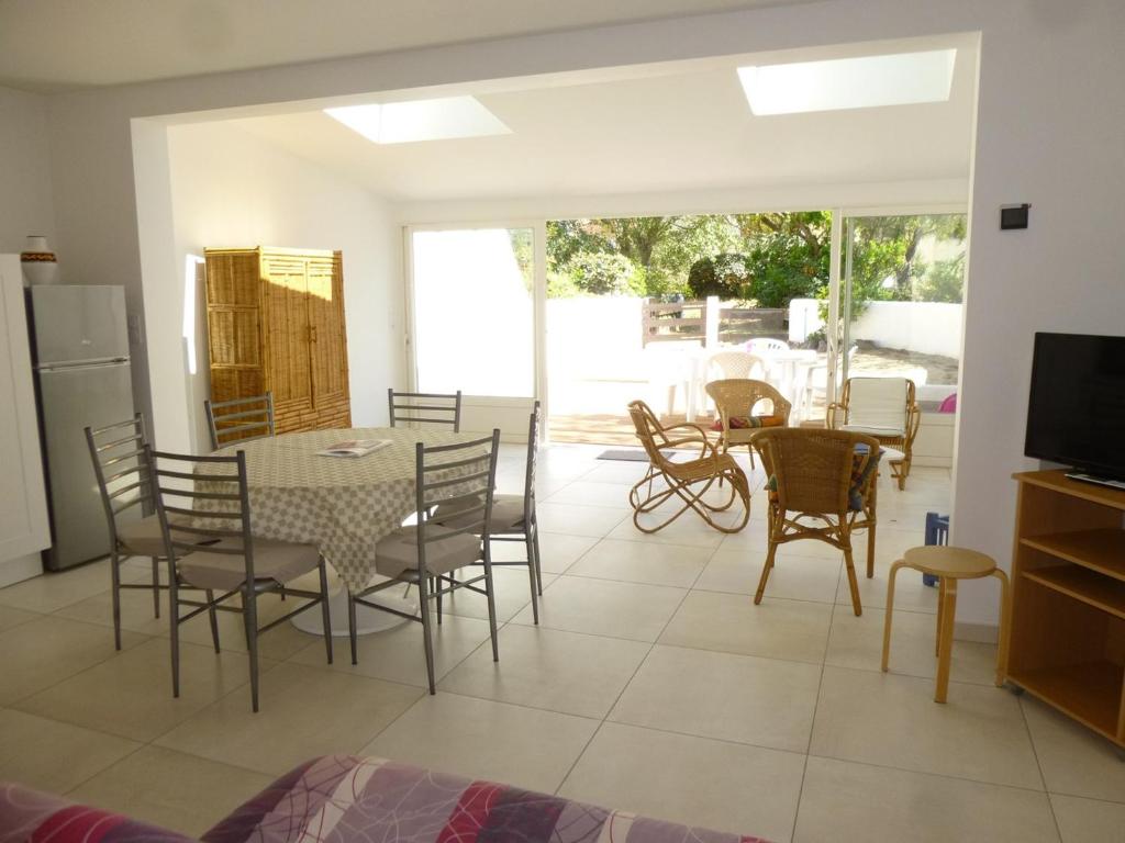 une cuisine et une salle à manger avec une table et des chaises dans l'établissement Maison refaite à neuf proche plage, 3 pièces, 6 couchages, jardin privé, parking inclus - FR-1-224C-156, à Saint-Jean-de-Monts