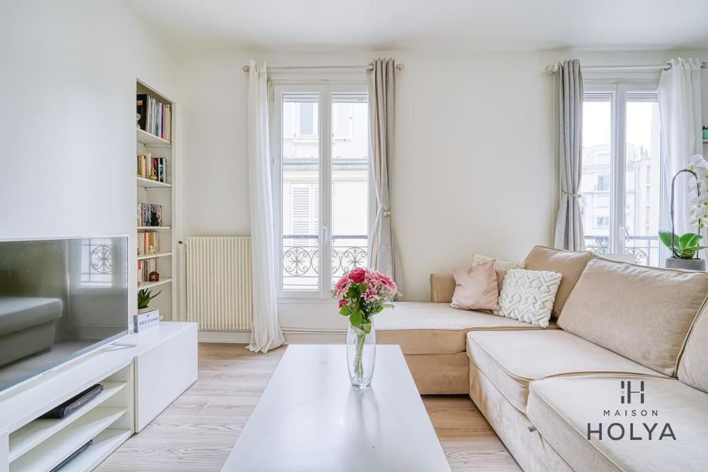 - un salon avec un canapé et un vase de fleurs sur une table dans l'établissement Quartier des Ternes - Le Rêveur - 137MB, à Paris