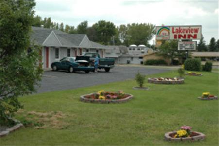 a yard with three flower beds in the grass at Lakeview Inn in Willmar
