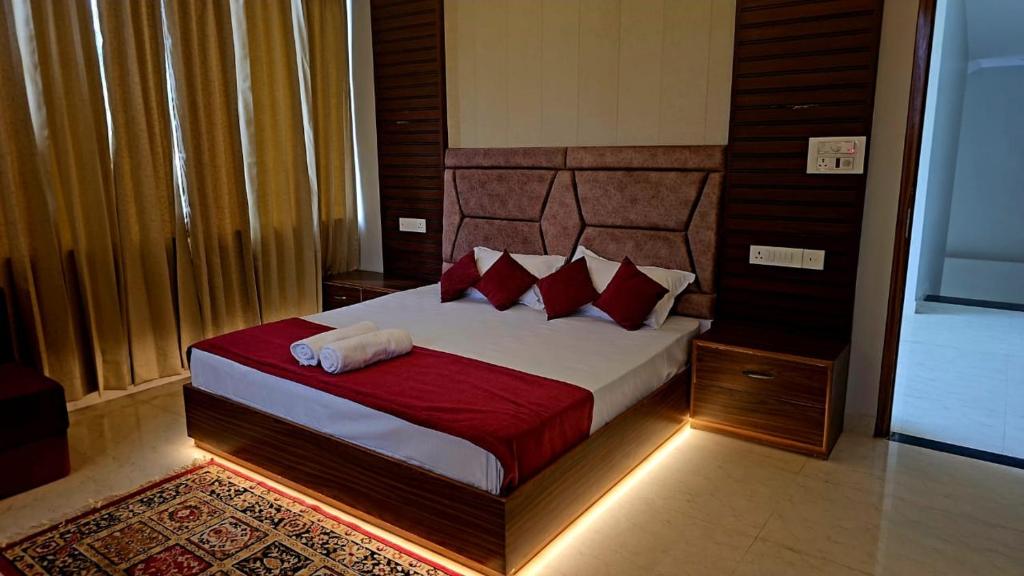 a bedroom with a large bed with red pillows at R Narayan pleasant Inn hotel in Gupta Kāshi