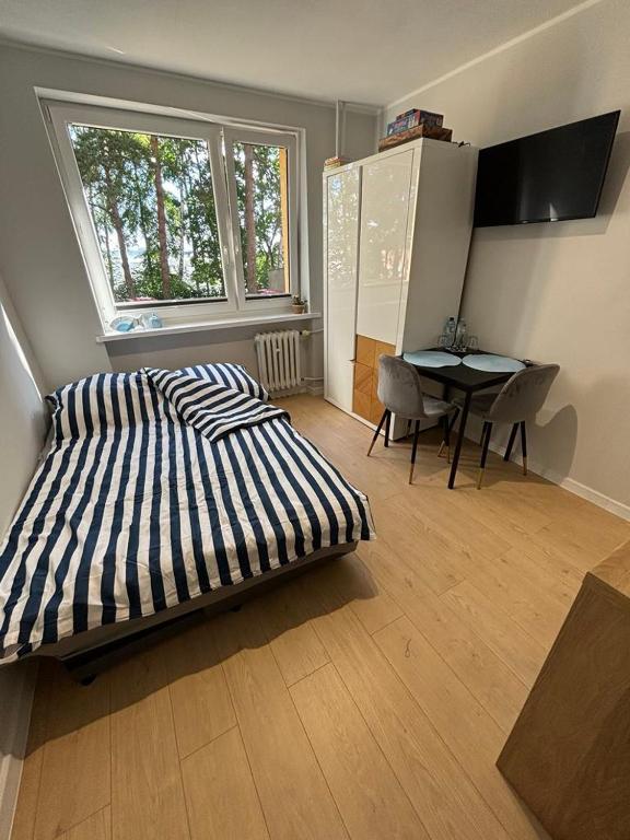 a bedroom with a bed and a table with chairs at A&P Studio in Gdynia