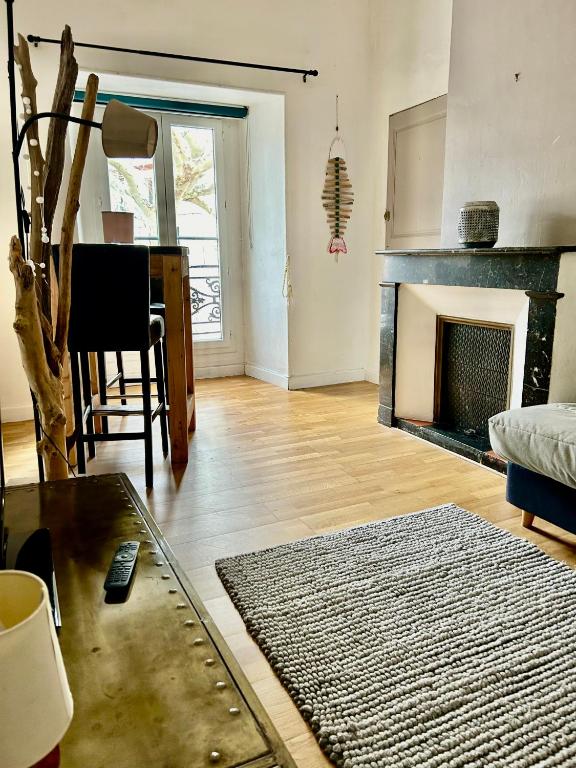 un salon avec une cheminée et une table dans l'établissement Charmant 2 pièces centre historique Béziers, à Béziers