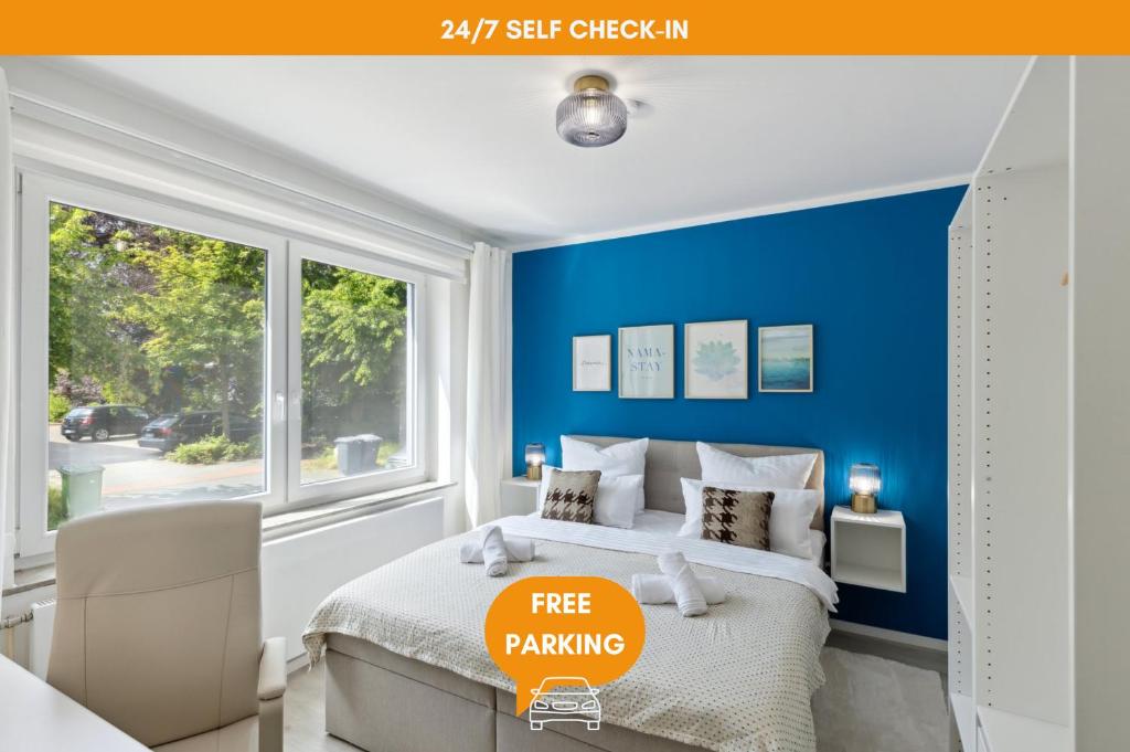 a blue bedroom with a bed and a window at AT WEINMEISTER - Großzügigkeit & Ruhe in Gütersloh