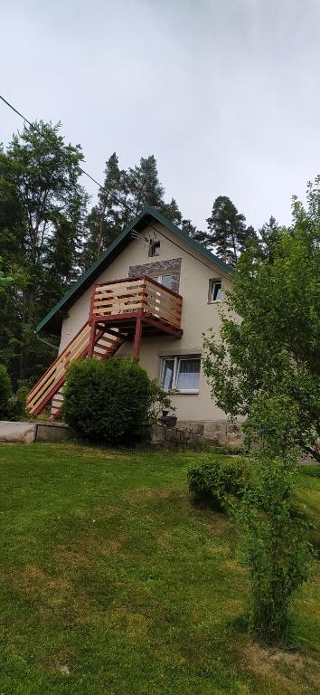 a house with a deck on the side of it at Apartmán u lesa u Adršpachu in Jívka