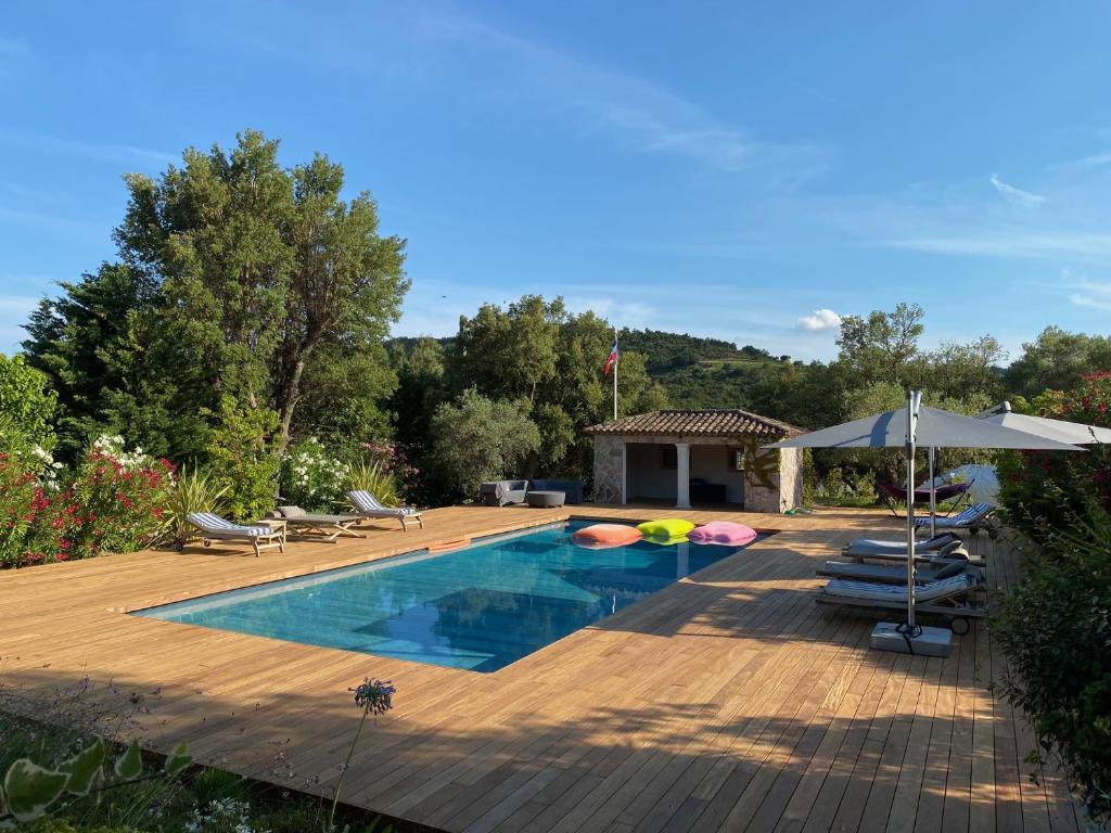 - une piscine avec une terrasse et un parasol dans l'établissement Villa au milieu du vignoble - Golfe de Saint Tropez, au Plan-de-la-Tour