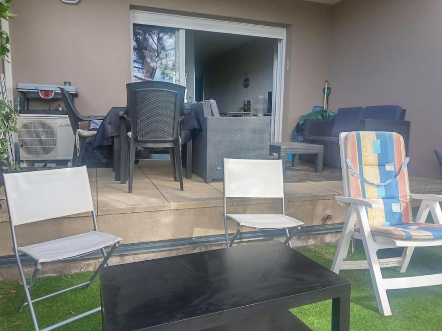 un groupe de chaises assises devant une maison dans l'établissement studio rez de jardin, à Fréjus