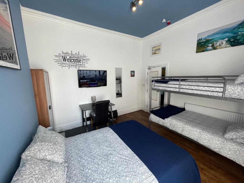 ein Schlafzimmer mit zwei Etagenbetten und einem Schreibtisch in der Unterkunft Backpackers Blackpool Hotel & Suites in Blackpool