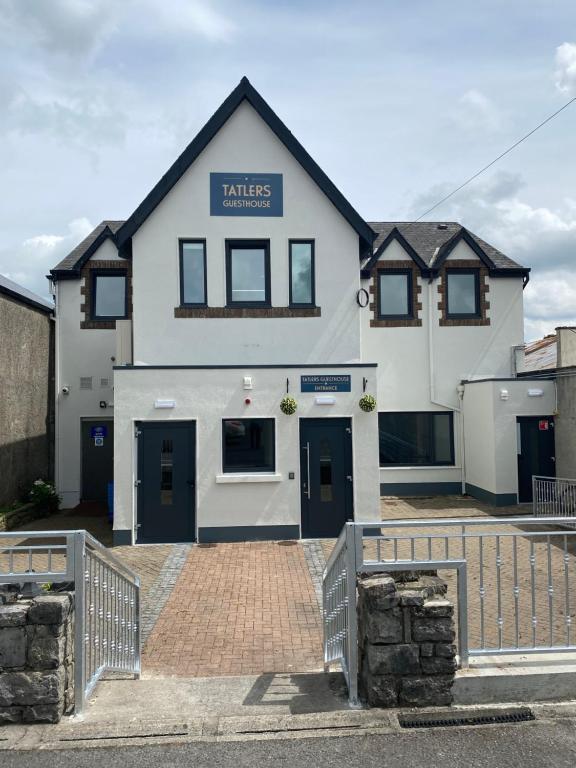 a white building with a sign that reads kates apartments at Tatlers Guest House in Roscommon