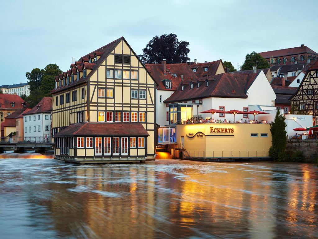 eine Gruppe von Gebäuden neben einem Fluss in der Unterkunft Hotel Nepomuk in Bamberg