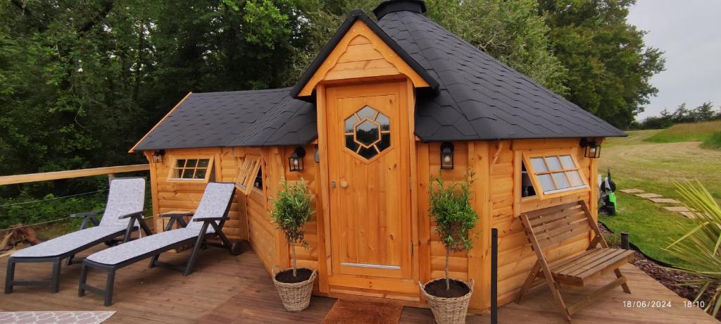 une grande cabane en bois avec un toit noir dans l'établissement Insolite KOTA avec SPA et demi Bt de champagne offerte, à Ruch