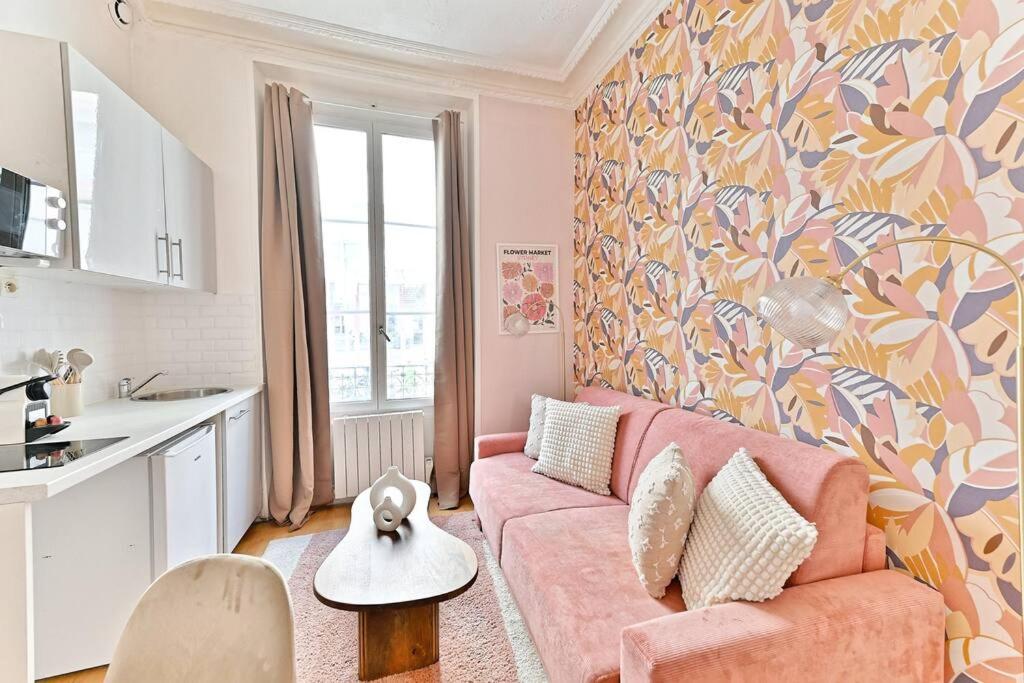 un salon avec un canapé rose et une cuisine dans l'établissement Magnifique appartement Neuf Rose Paris 14ème, à Paris