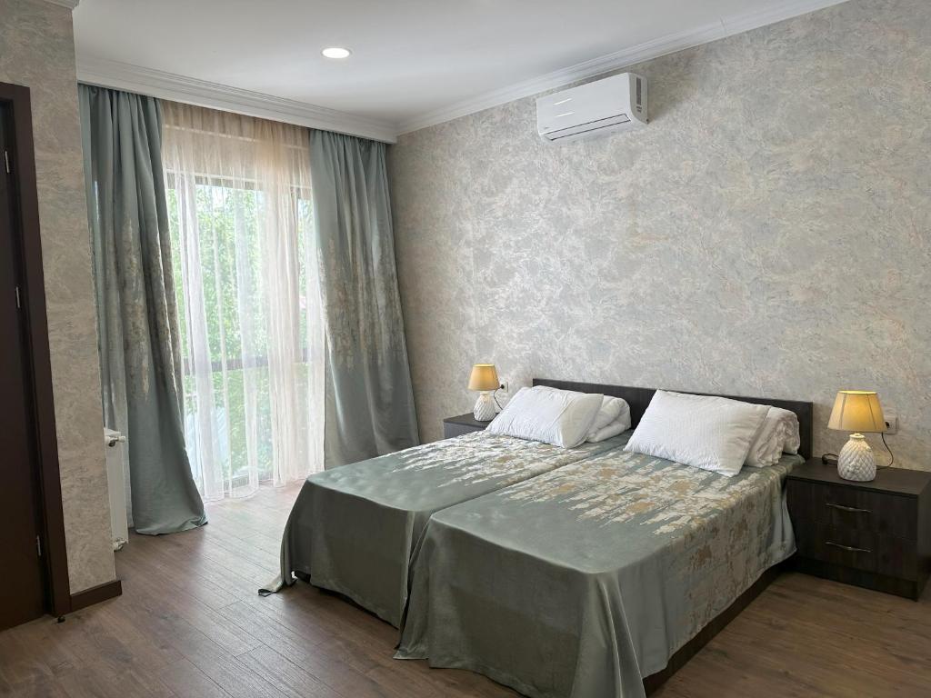 ein Schlafzimmer mit einem Bett und einem großen Fenster in der Unterkunft Three Palms Guest House in Tbilisi City
