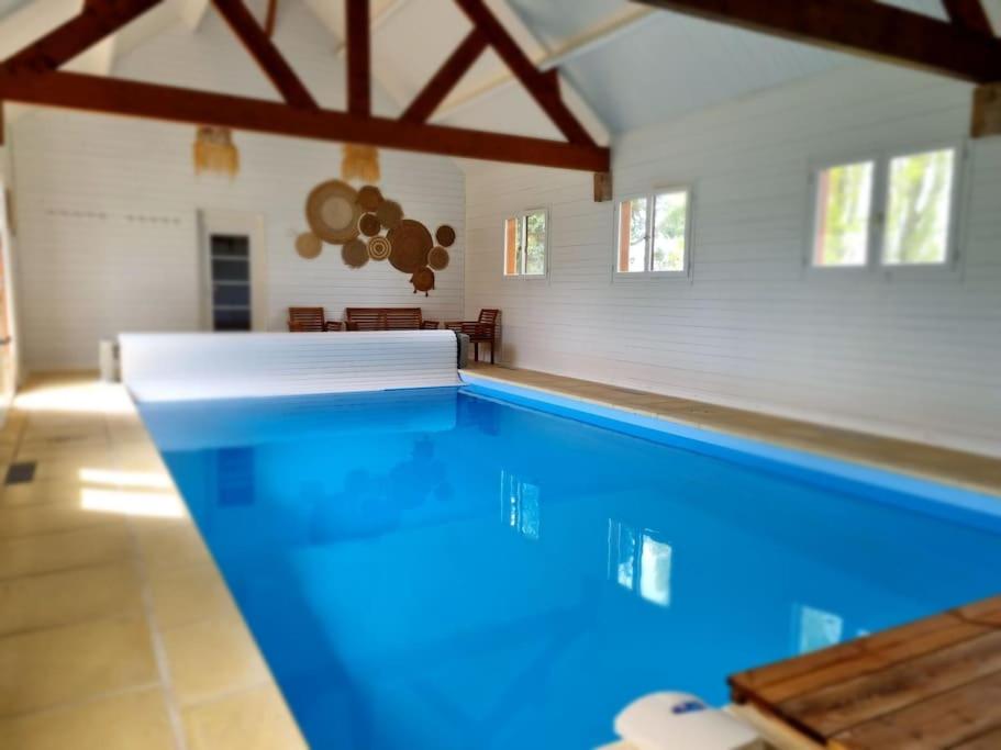 ein großer Pool in einem Haus mit in der Unterkunft La Longère avec Piscine in Saint-Martin-le-Gaillard