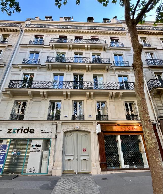 un grand bâtiment blanc avec des balcons sur une rue dans l'établissement Charmant appartement familiale, à Paris