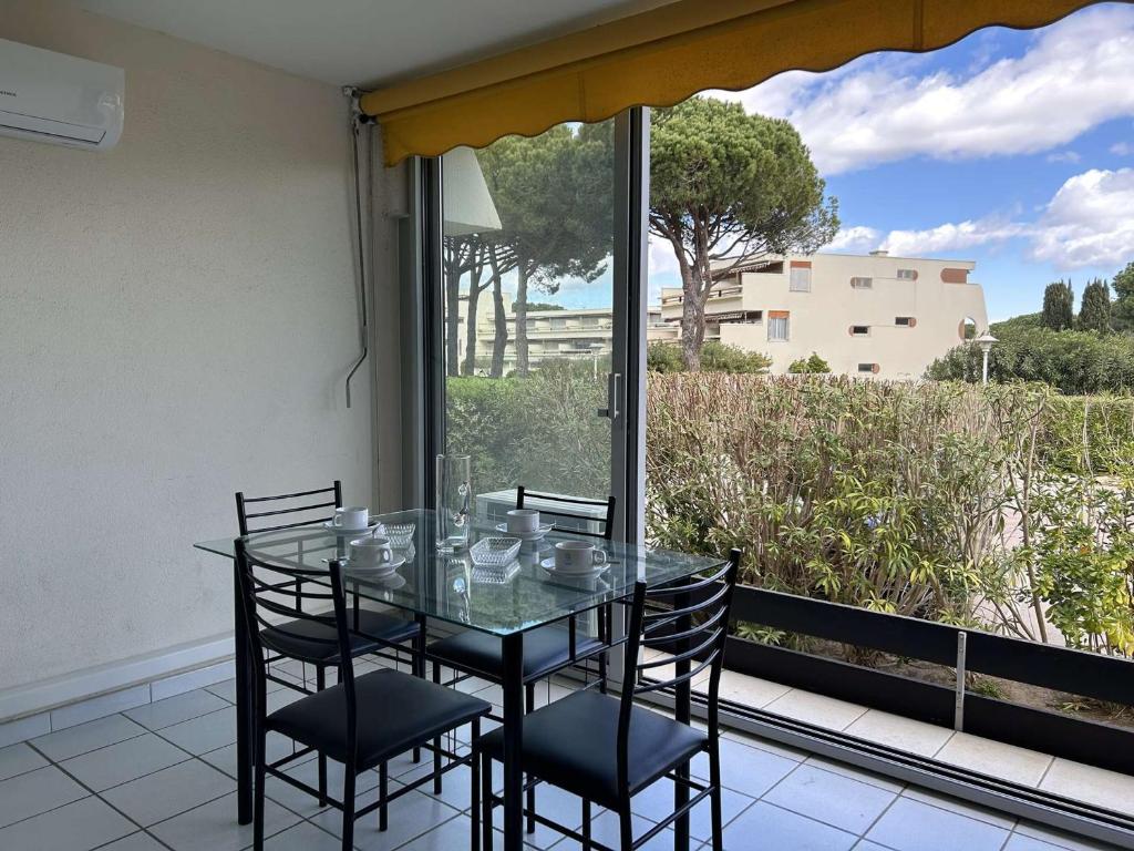 une table en verre et des chaises sur un balcon dans l'établissement Studio climatisé à Port Camargue - 4 couchages, terrasse, piscine, parking, proche plage - FR-1-250-9, au Grau-du-Roi