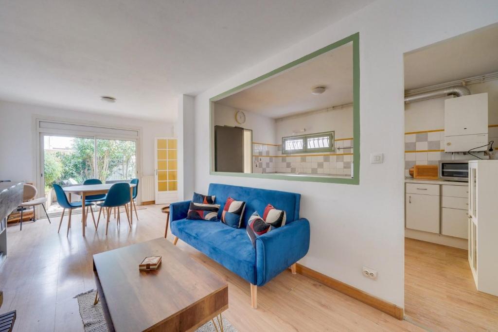 un salon avec un canapé bleu et une table dans l'établissement Maison de charme à Bacalan avec Terrasse, à Bordeaux