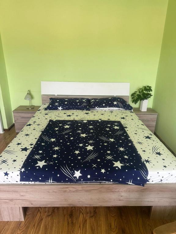 a bed with a black comforter with stars on it at Apartament La Ilie in Ocna Sibiului