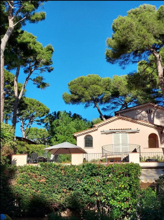 une maison avec une table et un parasol dans l'établissement Cap d'Antibes, swimming pool, sea, terrasse, à Antibes
