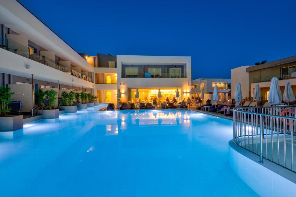 a large swimming pool in a hotel at night at White Olive Premium Laganas in Laganas