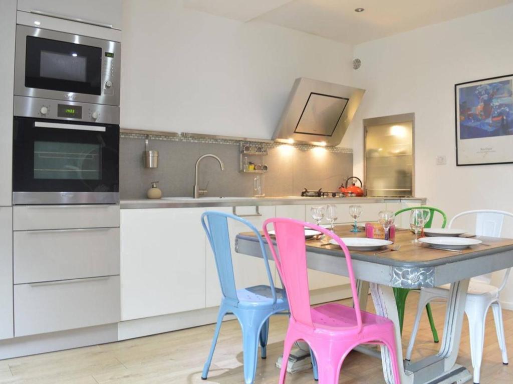 une cuisine avec une table et des chaises colorées dans l'établissement Maison de pêcheur rénovée, 5 couchages, proche plage et commerces, Banyuls-sur-Mer - FR-1-225C-546, à Banyuls-sur-Mer