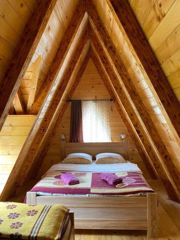 un lit dans le grenier d'une cabane en rondins dans l'établissement Holiday vikendica, à Žabljak