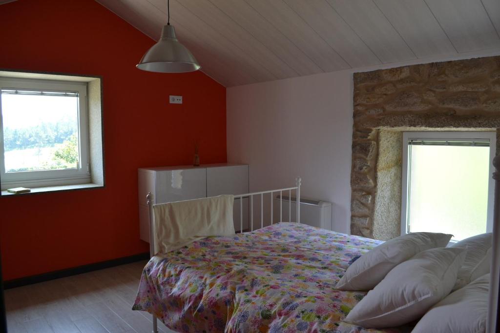 a bedroom with red walls and a bed with pillows at Casa de Moreira in Calo