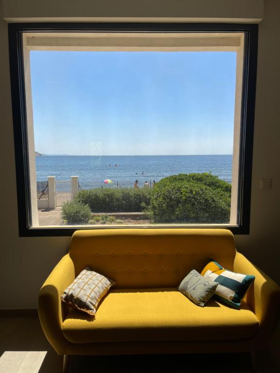 - un canapé en face d'une fenêtre avec vue sur la plage dans l'établissement Pleine mer, à La Seyne-sur-Mer