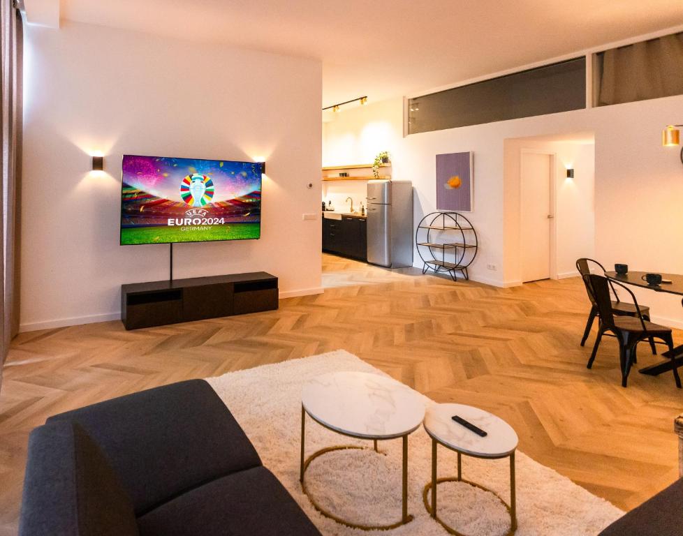 a living room with a couch and a tv on a wall at 6 persons Luxury Appartement in Citycentre Breda in Breda