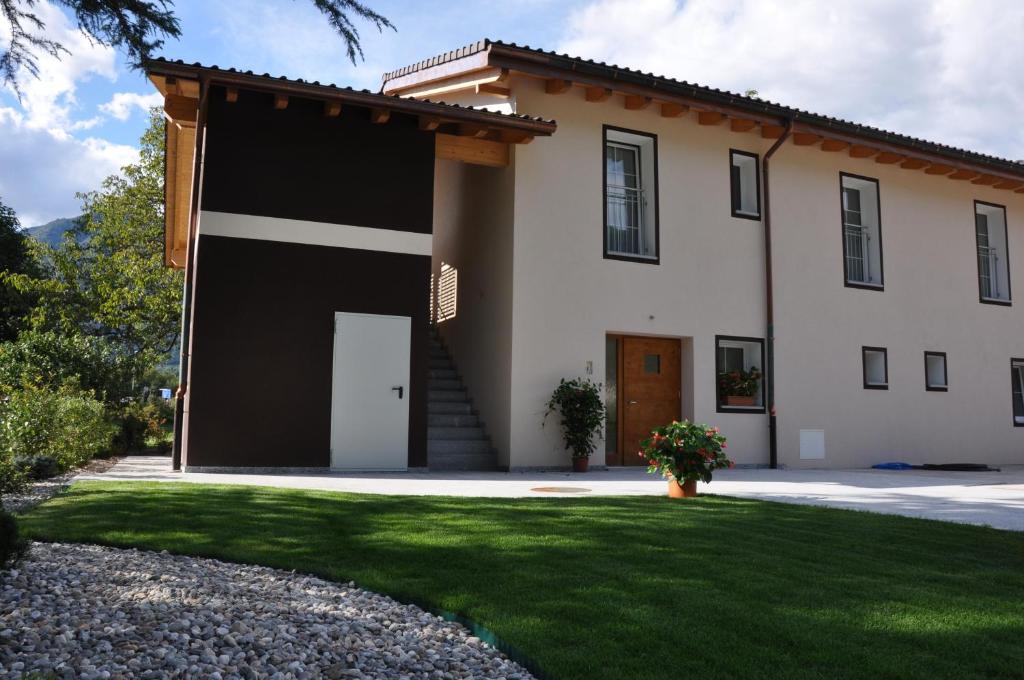 une grande maison blanche avec un garage noir dans l'établissement Agriturismo Regusci, à Camorino