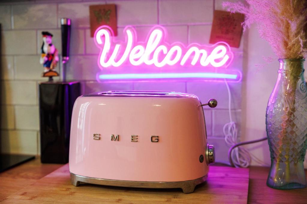 a toaster sitting on a table with a neon sign at Perle rare au coeur de Bordeaux - Bordeauxlidays in Bordeaux