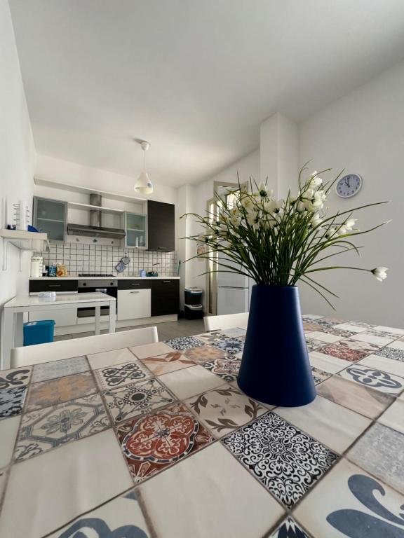 a kitchen with a table with a vase of flowers on it at Casa Vacanze Il Borghetto in Marzamemi