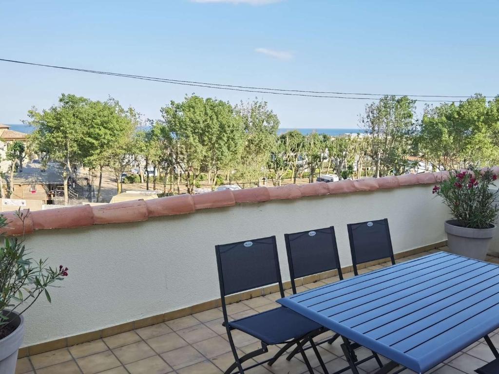 une table bleue et deux chaises sur un balcon dans l'établissement Appartement 2 pièces avec mezzanine et toit terrasse, Marseillan-Plage, 6 couchages - FR-1-326-720, à Marseillan