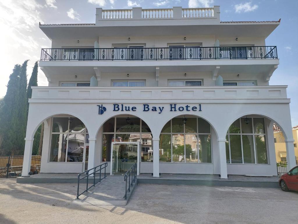 a white building with a blue bay hotel at Blue Bay Hotel in Iraklitsa