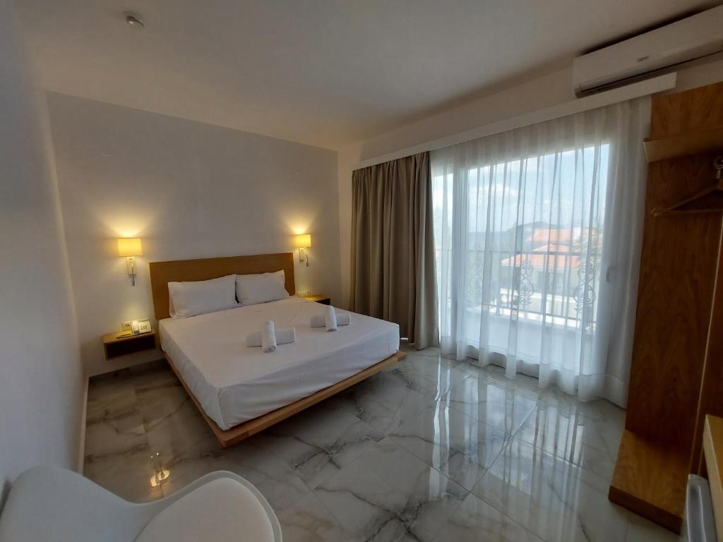 a bedroom with a bed and a large window at Blue Bay Hotel in Iraklitsa