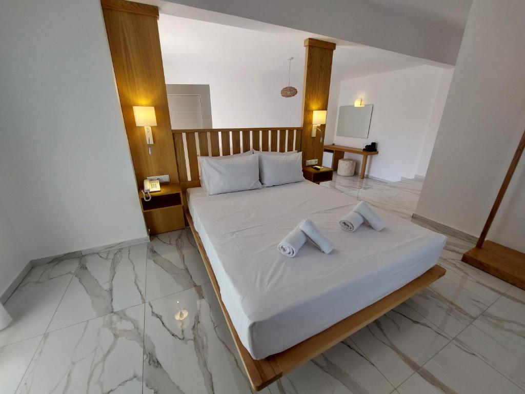 a bedroom with a bed with two towels on it at Blue Bay Hotel in Iraklitsa