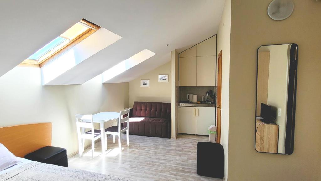 ein Zimmer mit einem Bett, einem Tisch und einer Küche in der Unterkunft Butukas Nidai in Nida